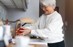 A woman washing vegatables in a sink